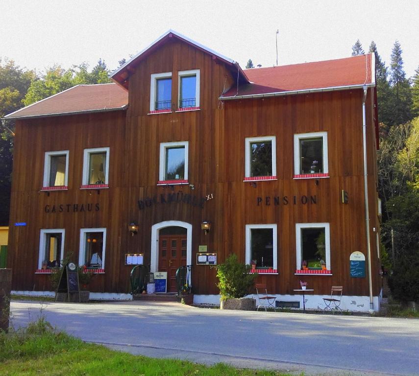 een groot houten gebouw met een rood dak bij FeWo Bockmühle in Hohnstein