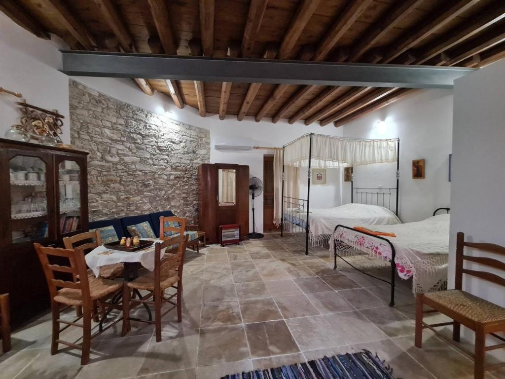 a bedroom with a bed and a table and chairs at Christiana's stone studios in Pano Lefkara