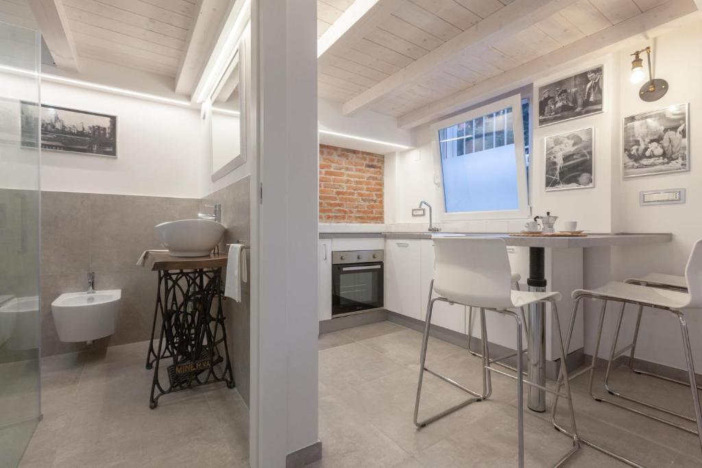 a kitchen with a sink and a counter with chairs at Loft-Relax in Bologna