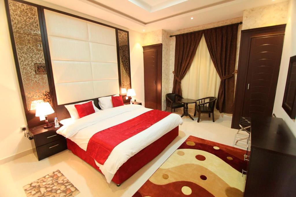 ein Schlafzimmer mit einem Bett und einem Tisch in einem Zimmer in der Unterkunft سكنا للشقق الفندقية in Buraida