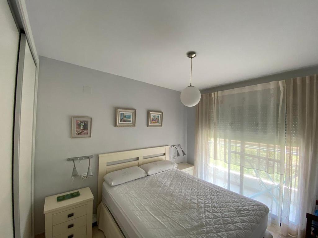 デニアにあるApartamento Aguamarの白いベッドルーム(ベッド1台、窓付)