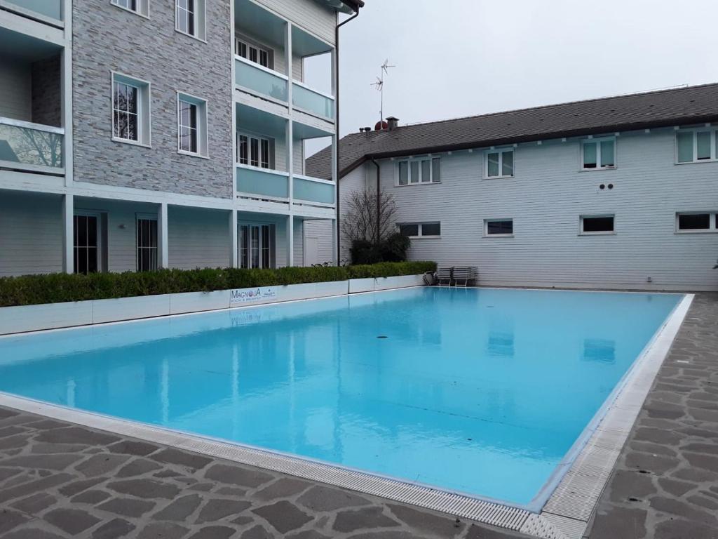 a large swimming pool in front of a building at Magnolia Room & Breakfast in Faenza