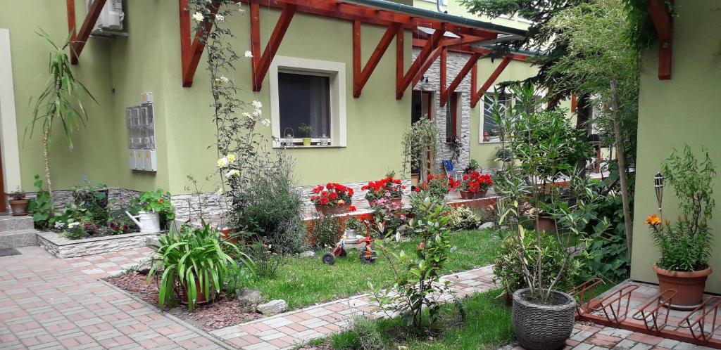 a garden in front of a house with flowers at Diána Apartmanház in Keszthely