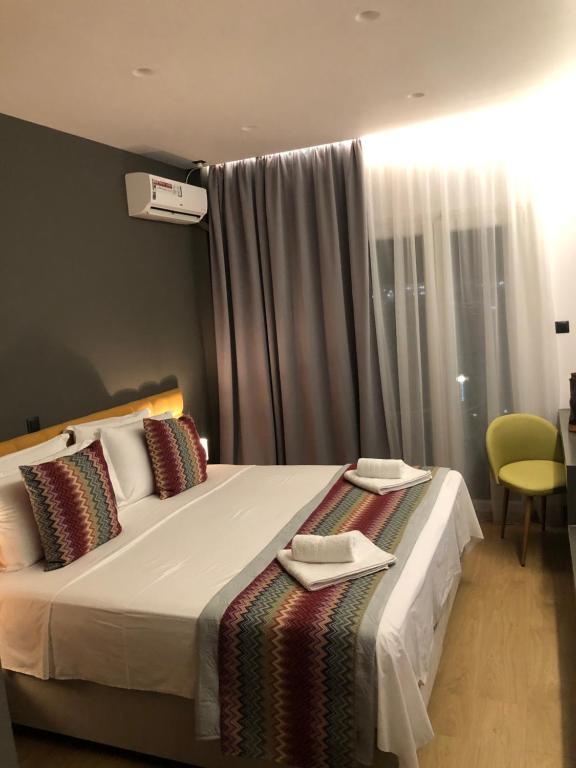 - une chambre avec un grand lit et des serviettes dans l'établissement Metropolitan Complex Suite Faliro, au Pirée
