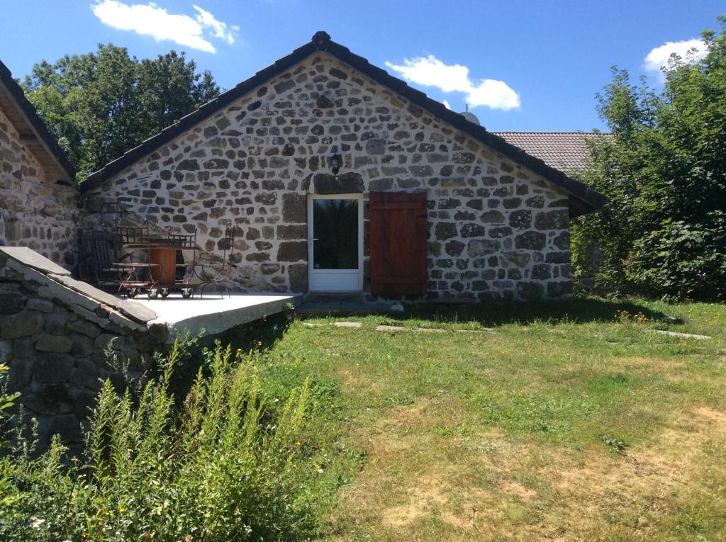 an outside view of a stone building with a door at La Bonbonnière in Le Chambon-sur-Lignon