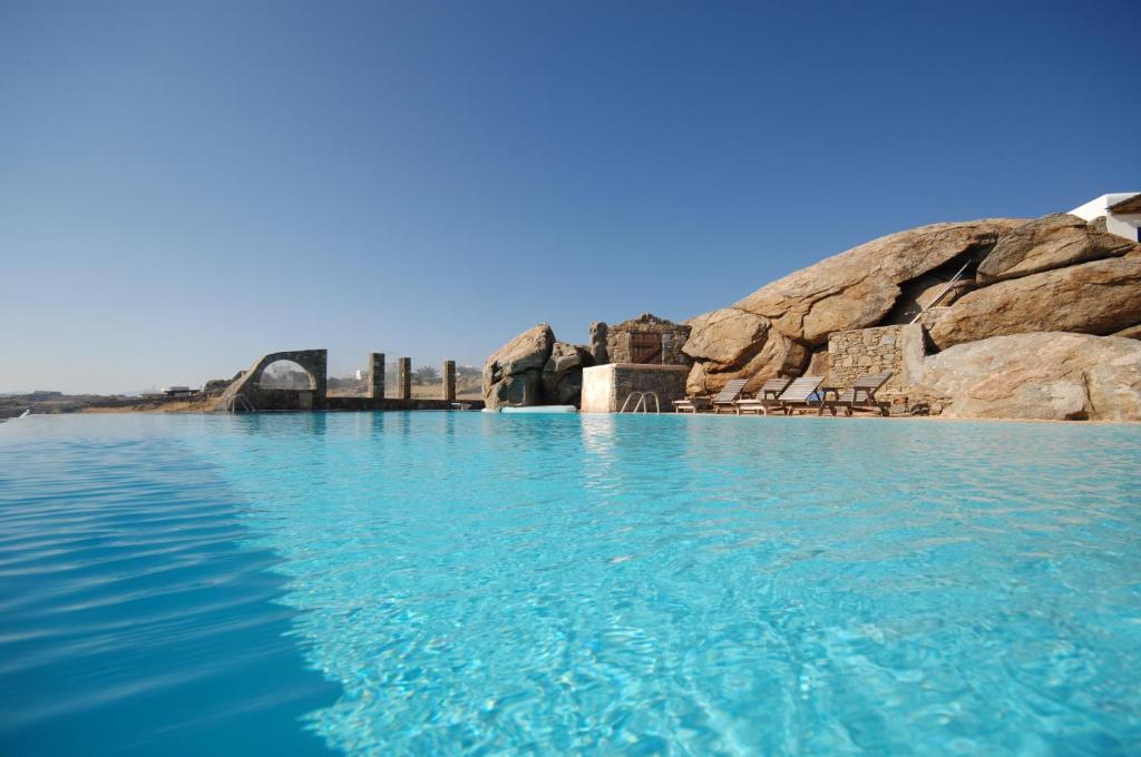 duży zbiornik wody obok niektórych skał w obiekcie Nafsika 4Bedroom Sea View House w mieście Mykonos