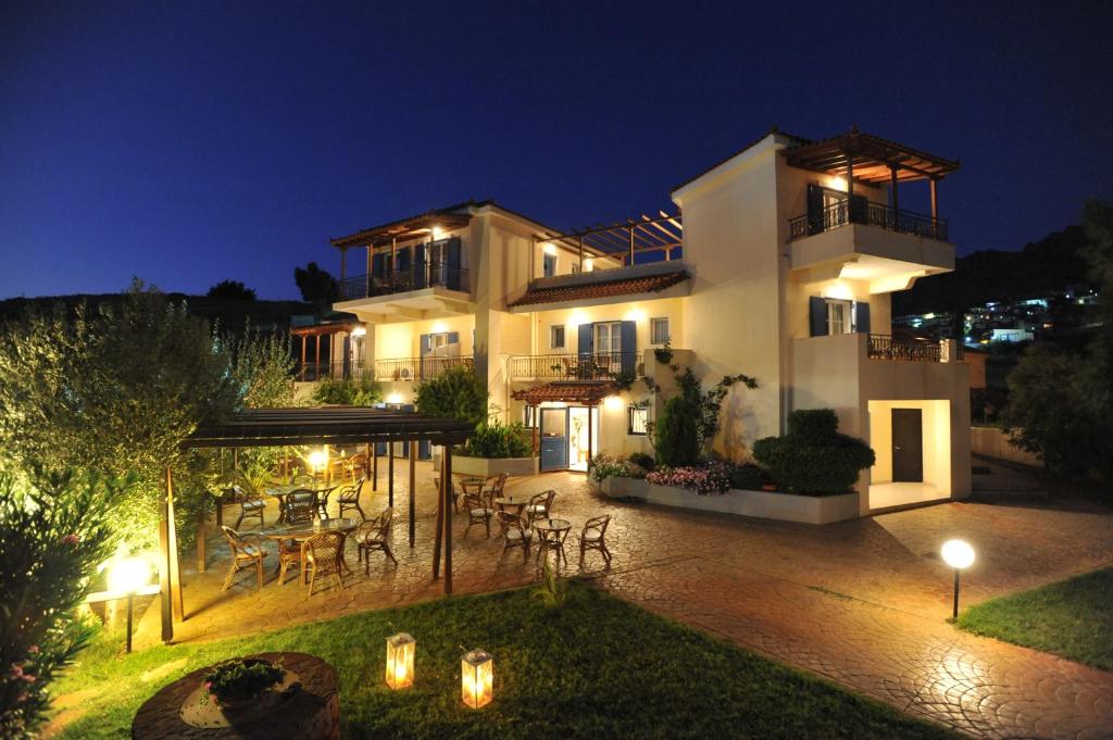 a large white house with a patio at night at Fereniki Studios in Platy