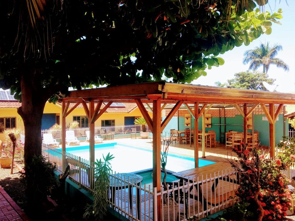 uma piscina com um pavilhão ao lado de um edifício em Pousada Don Blu em Itaipulandia