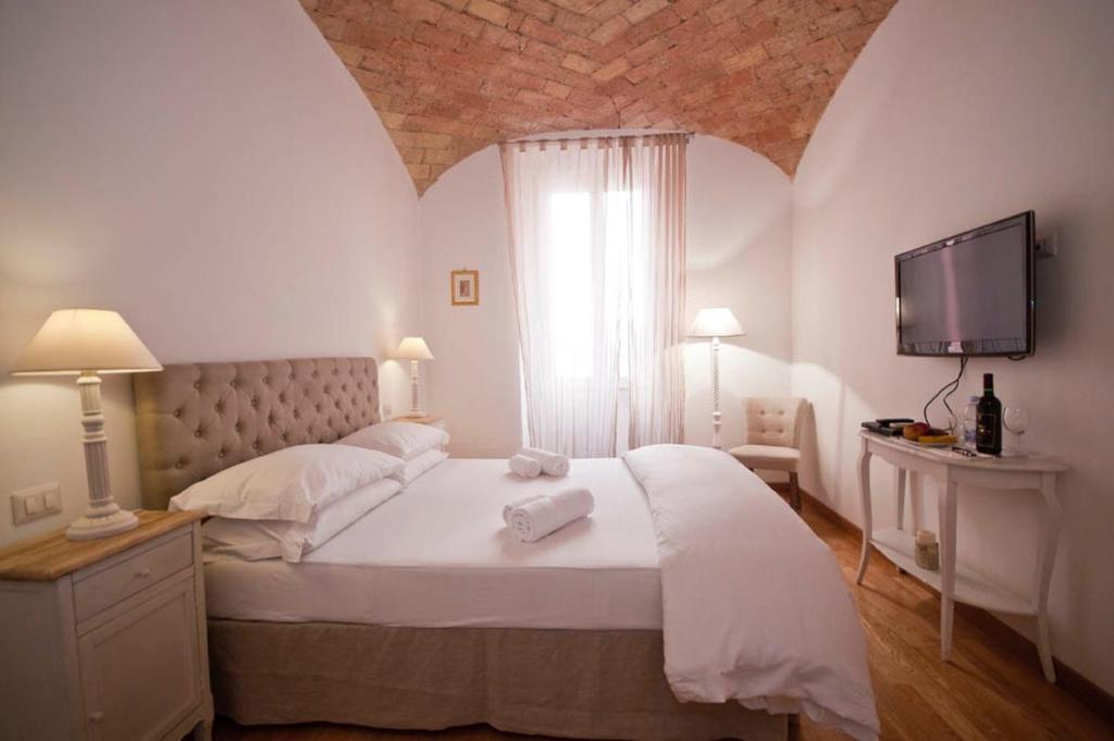 sypialnia z dużym łóżkiem z telewizorem na ścianie w obiekcie La finestra sul Colosseo B&B 1 w Rzymie