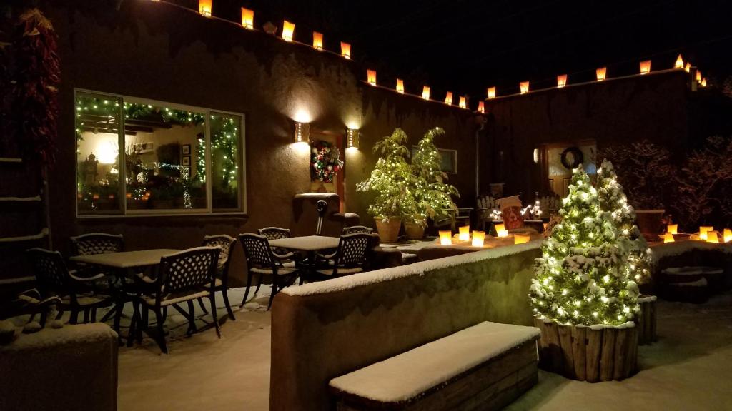 a christmas tree in a restaurant with tables and chairs at Inn on the Rio in Taos