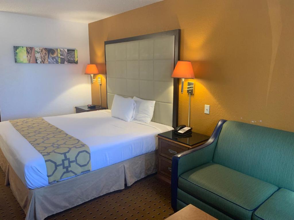 a hotel room with a bed and a chair at Brentwood Inn & Suites in Hobbs