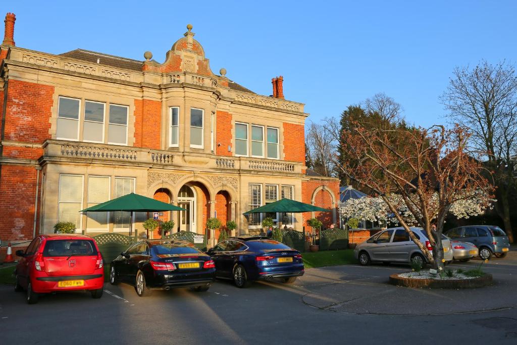 eine Gruppe von Autos, die vor einem Gebäude geparkt sind in der Unterkunft Millfields Hotel in Grimsby