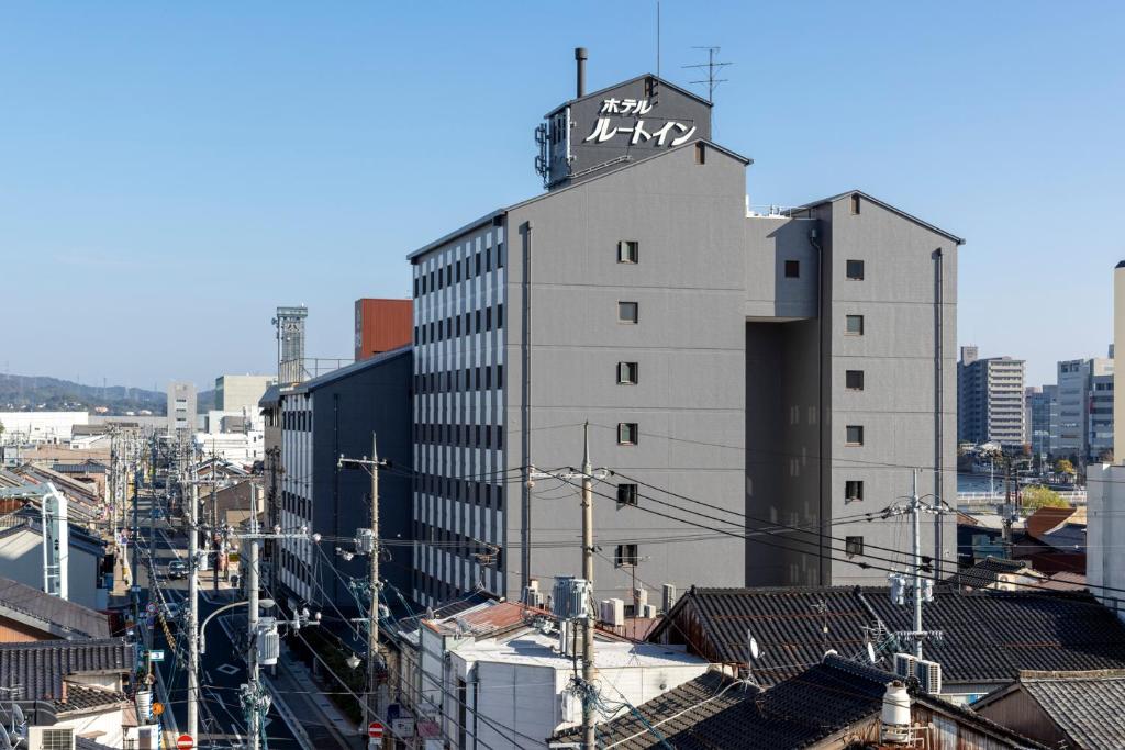 un edificio alto con un cartel en la parte superior en Hotel Route Inn Matsue en Matsue