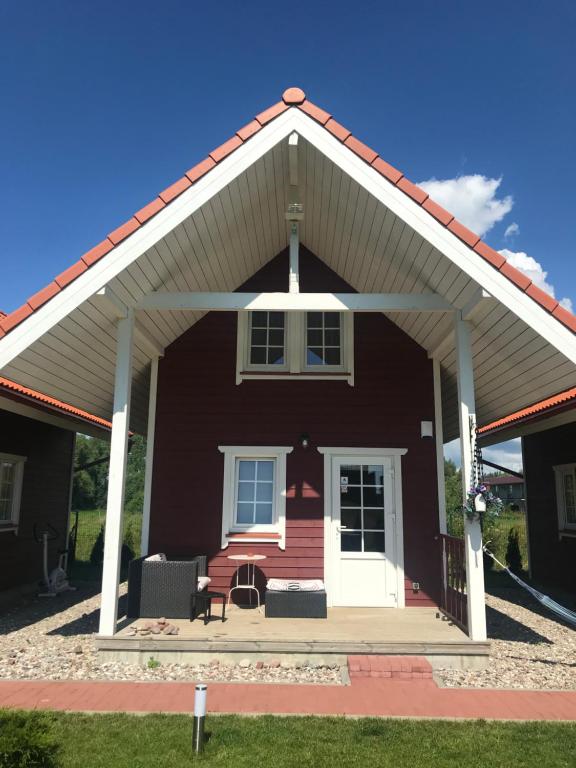 a red house with a pitched roof at Baltic Dream Vasarnamiai in Šventoji