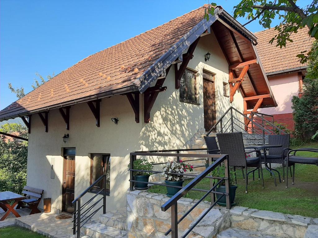 uma casa com um telhado com uma mesa e cadeiras em Apartmani Ogi i Ana em Bajina Bašta