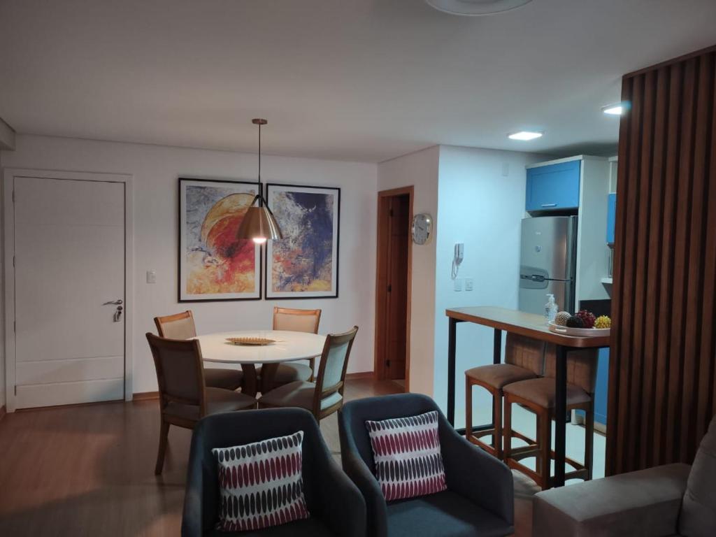 een keuken en eetkamer met een tafel en stoelen bij Flores da Montanha 402A in Gramado