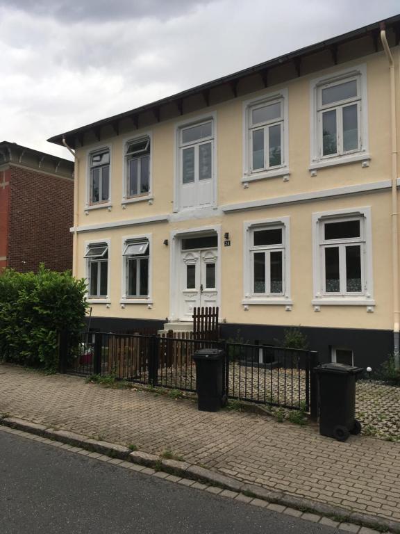 a white house with white windows and a fence at Wohnung Frida in Pinneberg