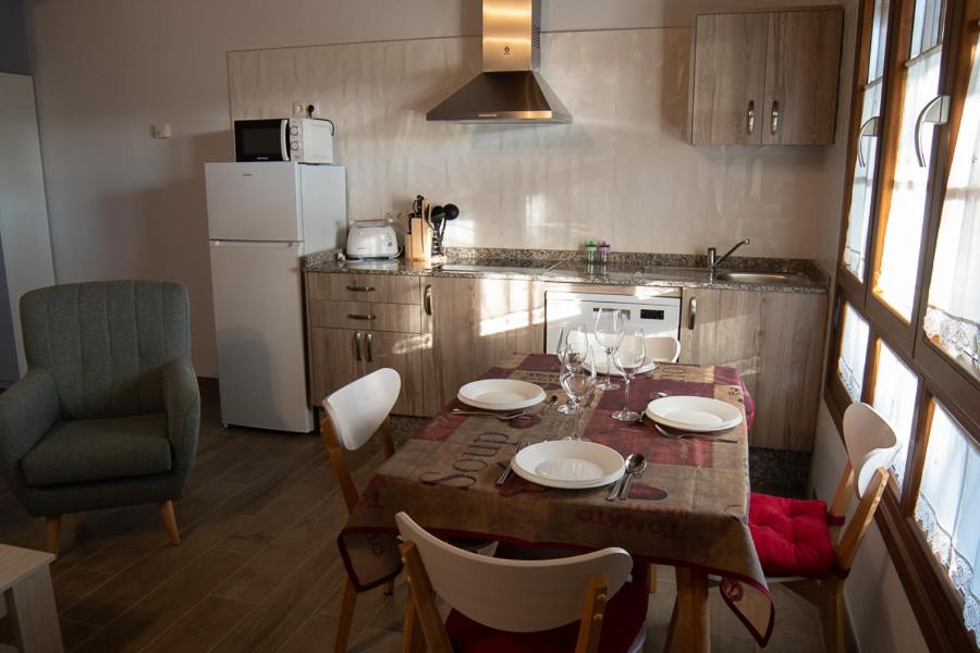 een keuken met een tafel en stoelen en een keuken met een tafel en een stoeltje bij Apartamentos Rurales Camín Real in La Caridad