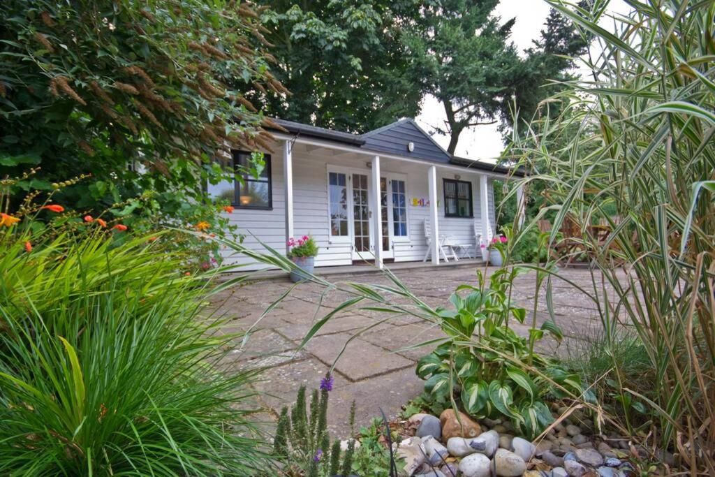 ein kleines weißes Haus inmitten eines Gartens in der Unterkunft Sailaway perfect romantic break in Norwich