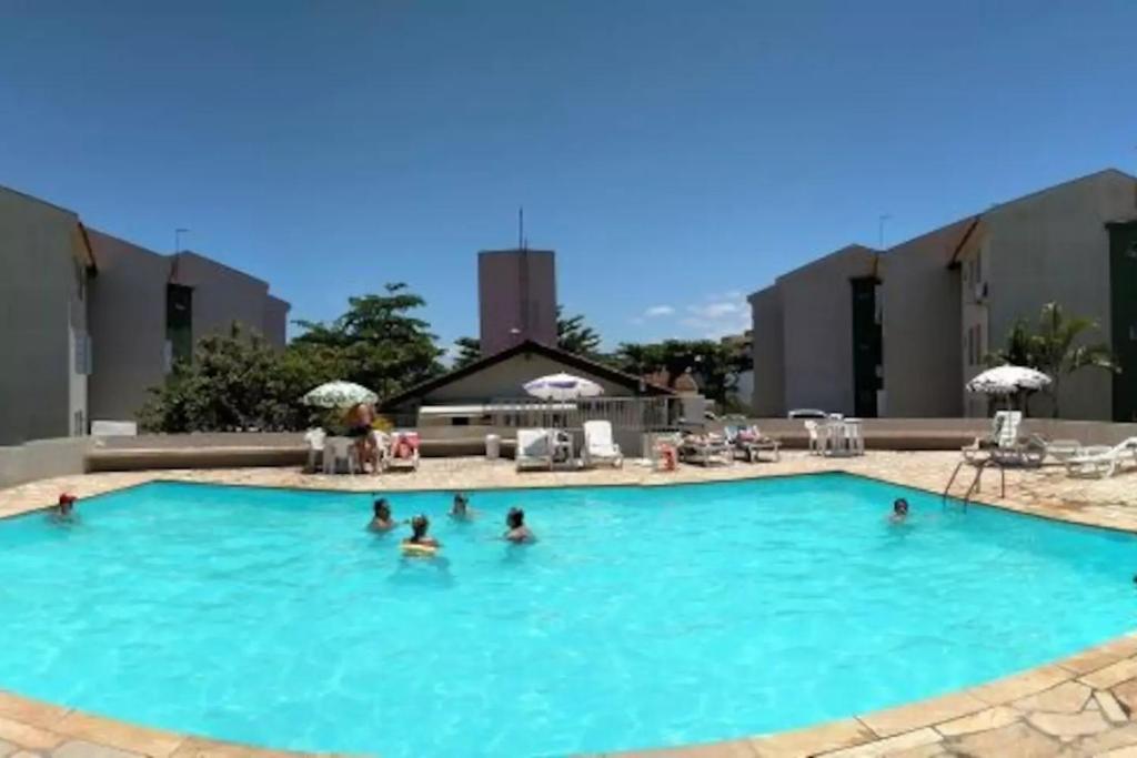 a group of people in a large swimming pool at APTO TÉRREO a 50 Metros do MAR em Condomínio com PISCINAS MARAVILHOSAS in Guaratuba