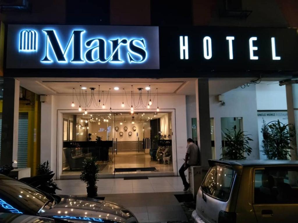 een man die voor een mans hotel loopt bij Mars Hotel in Kuala Lumpur