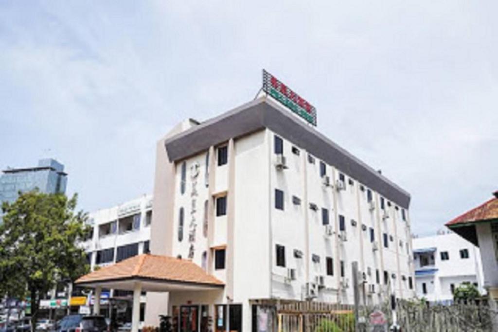 a white building with a sign on top of it at Palace Inn in Miri