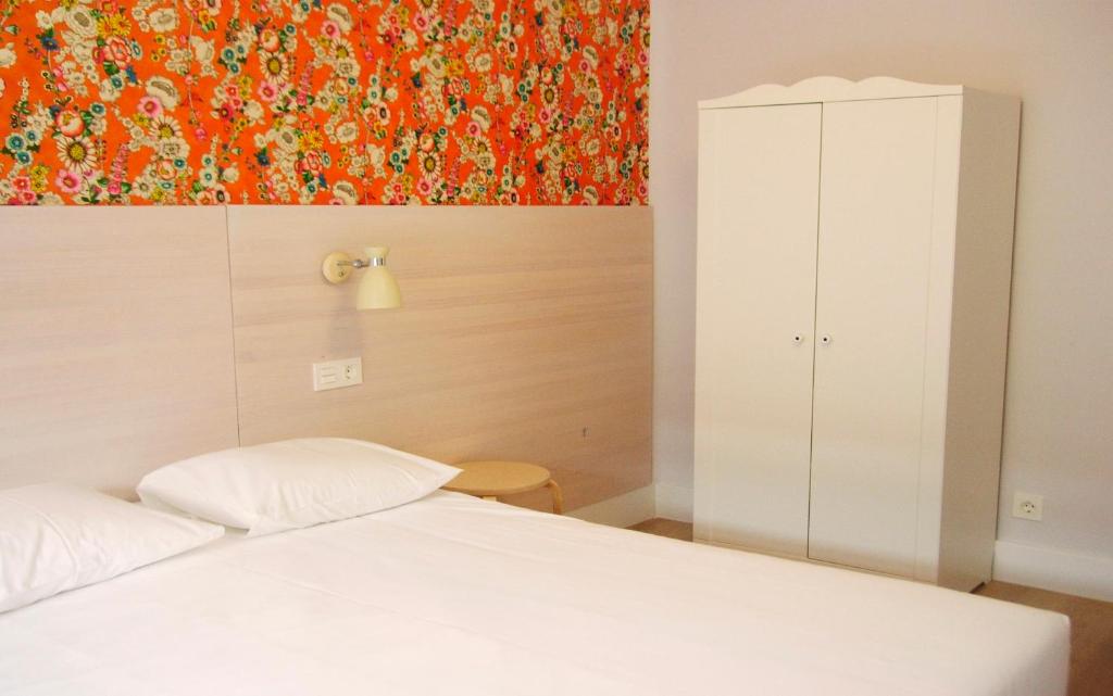 1 dormitorio con 1 cama y una pintura en la pared en Boreal Calima, en Burgos