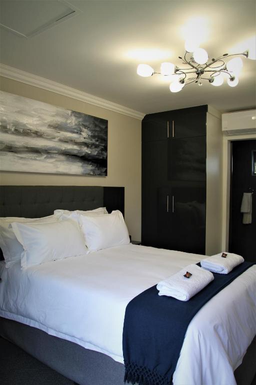 a bedroom with two beds with towels on them at Mahem Manor Guesthouse in Brits