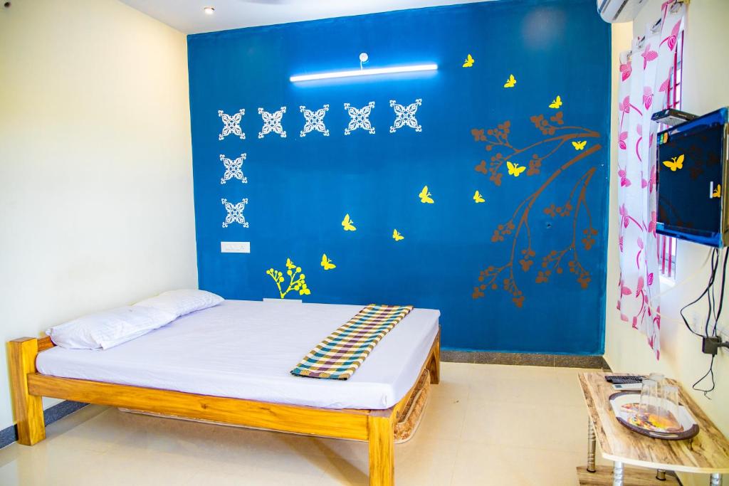 - une chambre dotée d'un lit avec un mur bleu dans l'établissement sea house, à Pondichéry