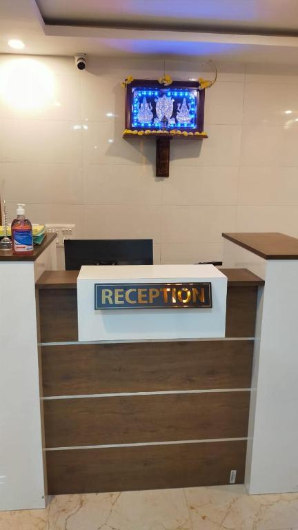 a reception desk with a keep top sign on the wall at Bhumi Residency in Mangalore