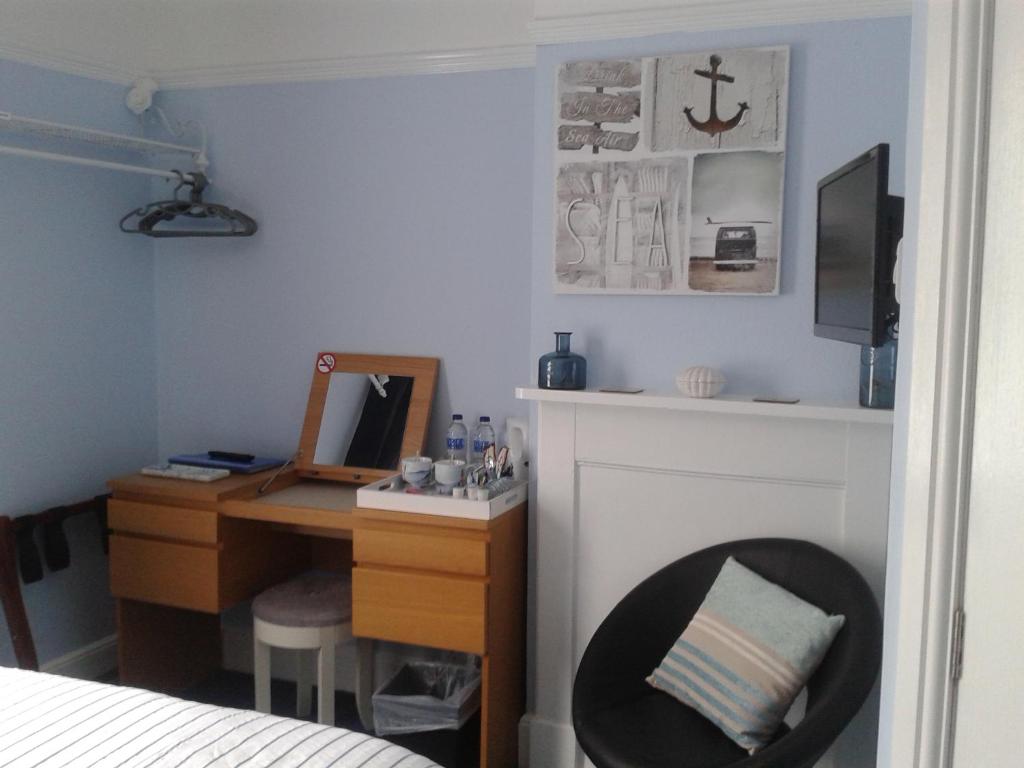 1 dormitorio con escritorio, 1 cama y escritorio con ordenador en South Rising Guest House en Poole