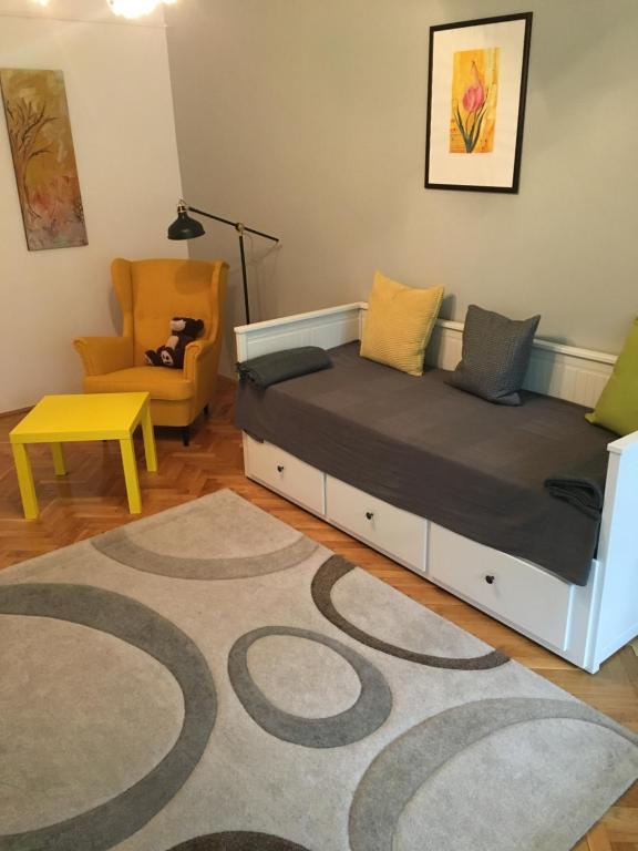 una camera con un letto, una sedia e un tappeto di Pálma apartman a Szentes