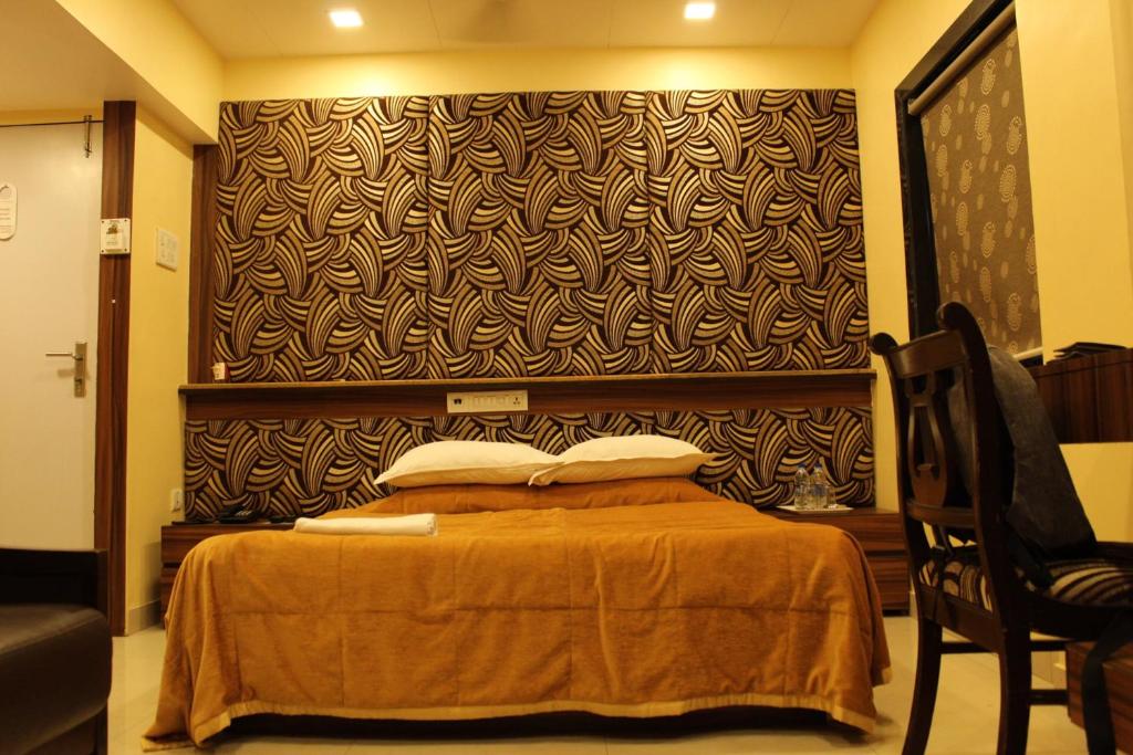 1 dormitorio con 1 cama y una pared grande en Hotel Metro Palace, en Bombay