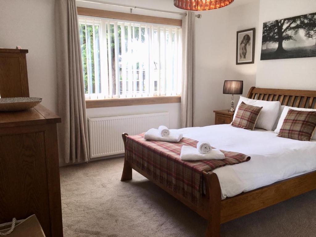 - une chambre avec un lit et 2 serviettes dans l'établissement Culduthel Cottage, à Inverness