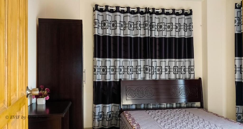 a bedroom with a bed and a black curtain at EViF Home Stay in Dhaka