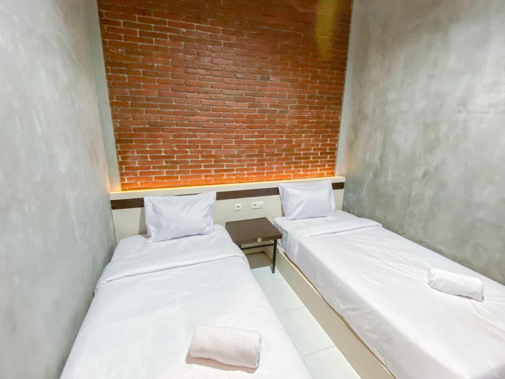 Postel nebo postele na pokoji v ubytování RedDoorz Syariah At Mitra Guest House