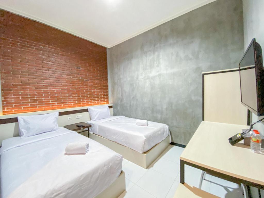 Postel nebo postele na pokoji v ubytování RedDoorz Syariah At Mitra Guest House