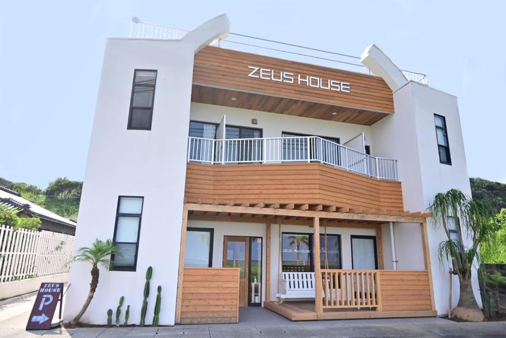 un bâtiment avec un panneau indiquant zeus house dans l'établissement Zeus House, à Nishinoomote