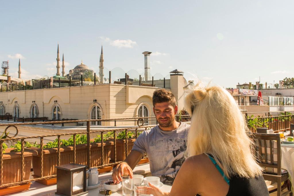 un homme et une femme assis à une table dans l'établissement Deniz Houses, à Istanbul