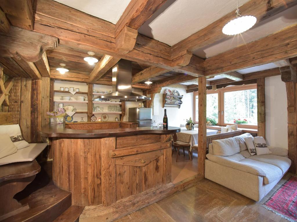 una cocina con paredes de madera y un bar en una casa en Residence Salvan, en Corvara in Badia