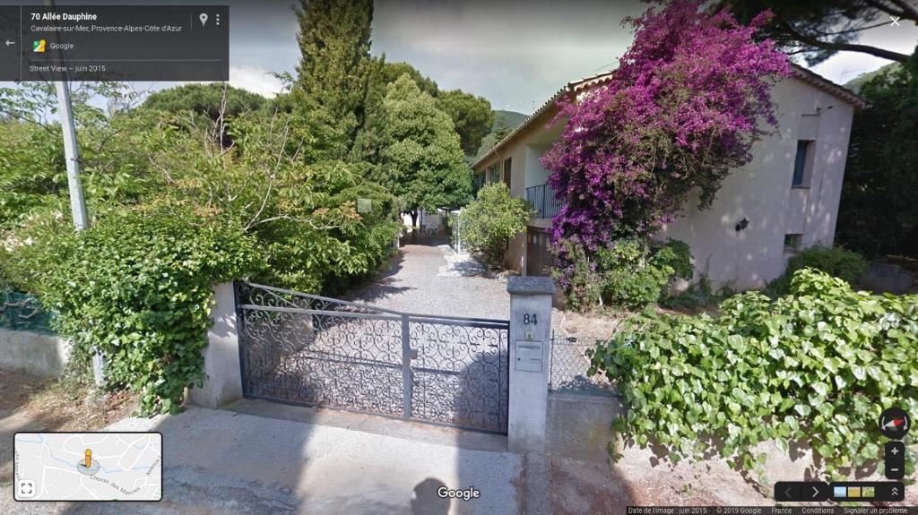 une porte menant à une maison ornée de fleurs violettes dans l'établissement Appartement classé 3 étoiles au 1er étage d'une maison avec jardin dans un quartier calme, à Cavalaire-sur-Mer