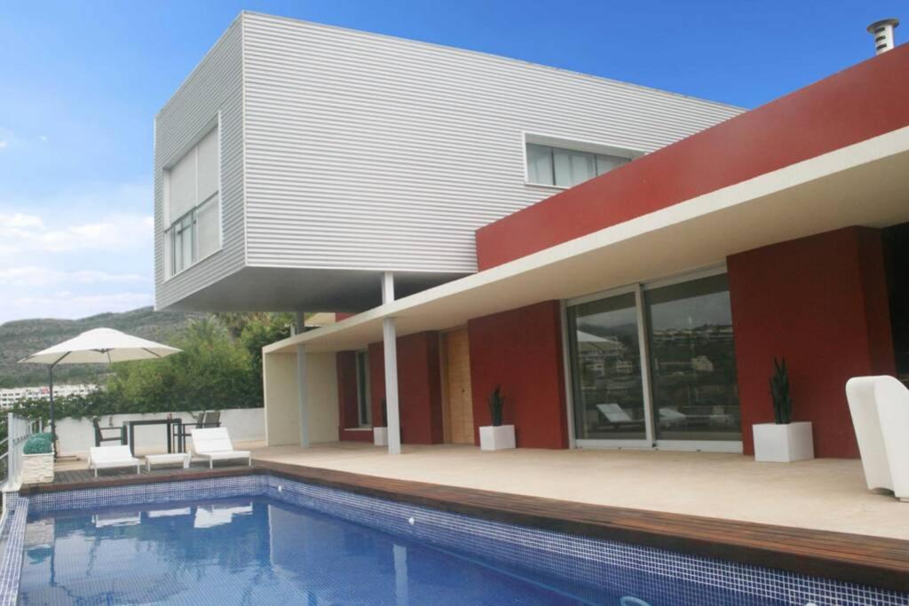 una casa con piscina al lado de un edificio en CasadelaLuzBenicasim, diseño y lujo, en Oropesa del Mar