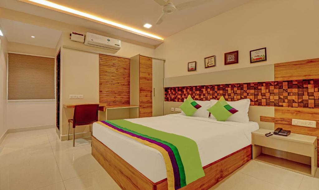 ein Schlafzimmer mit einem großen Bett und einem Schreibtisch in der Unterkunft Treebo Trend Rainbow Grand in Visakhapatnam