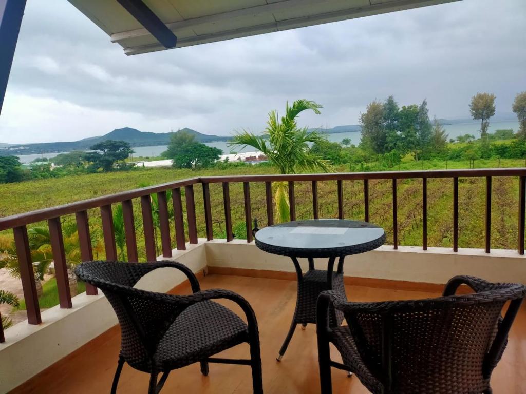 a patio with two chairs and a table on a balcony at Soma Vineyard Resort -Nashik in Nashik