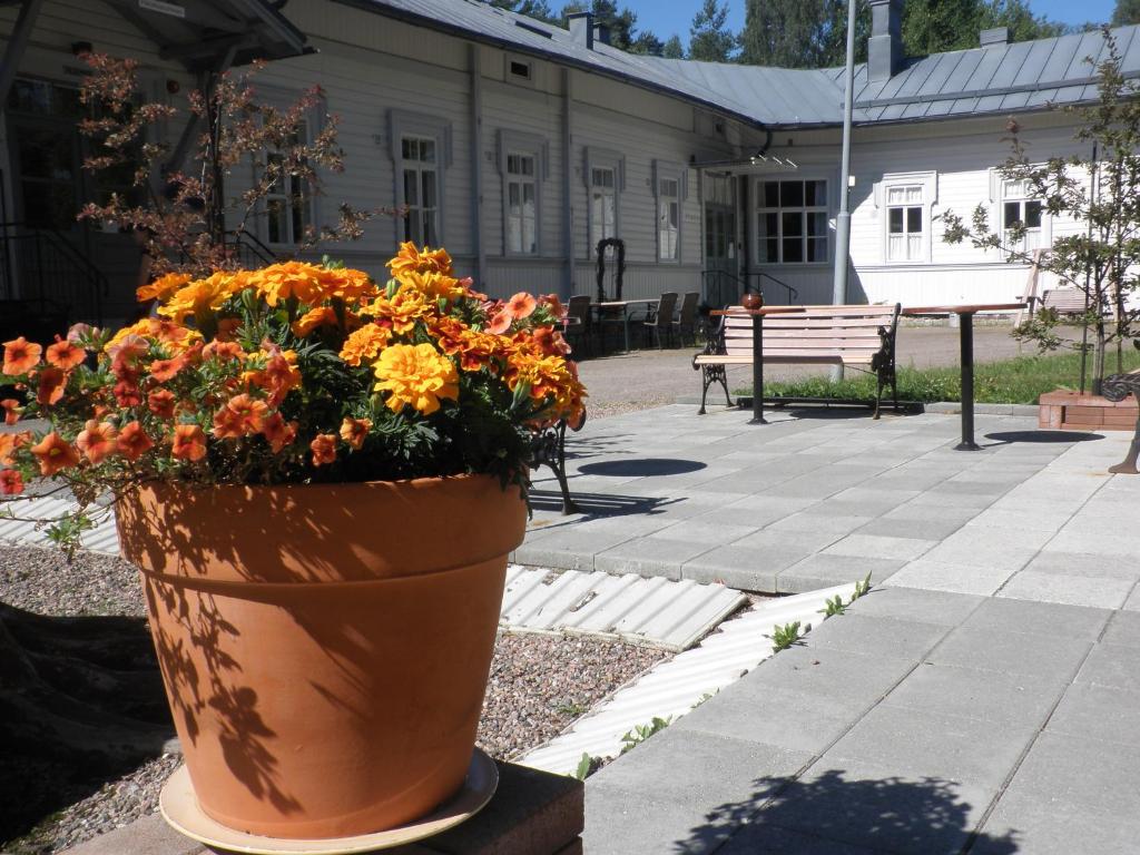 un jarrón lleno de flores sentado en una acera en Ulrikanhovi, en Lovisa