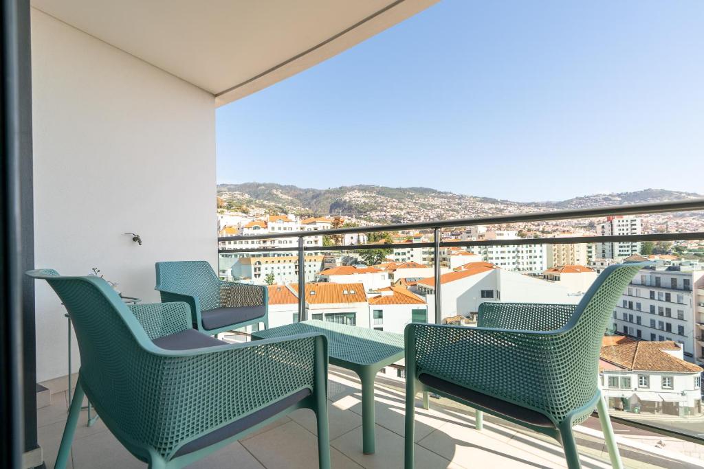 a balcony with chairs and a view of the city at Casa dos Filhos by Rent2U, Lda in Funchal