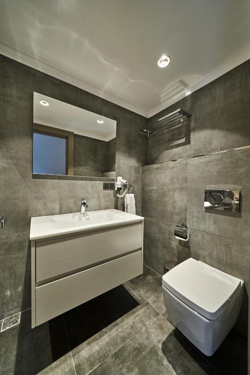 a bathroom with a sink and a toilet and a mirror at Selini Hotel İstanbul Airport in Istanbul