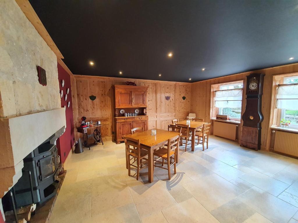 a large kitchen with wooden tables and a fireplace at Chambres d'hôtes La Carrée in Les Fins