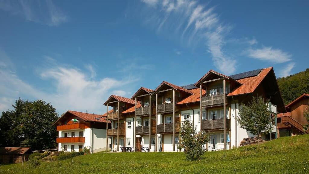 a large building with red roofs on a hill at Gasthof Zum Wirt Ferienwohnung Hohenbogenblick in Neukirchen beim Heiligen Blut