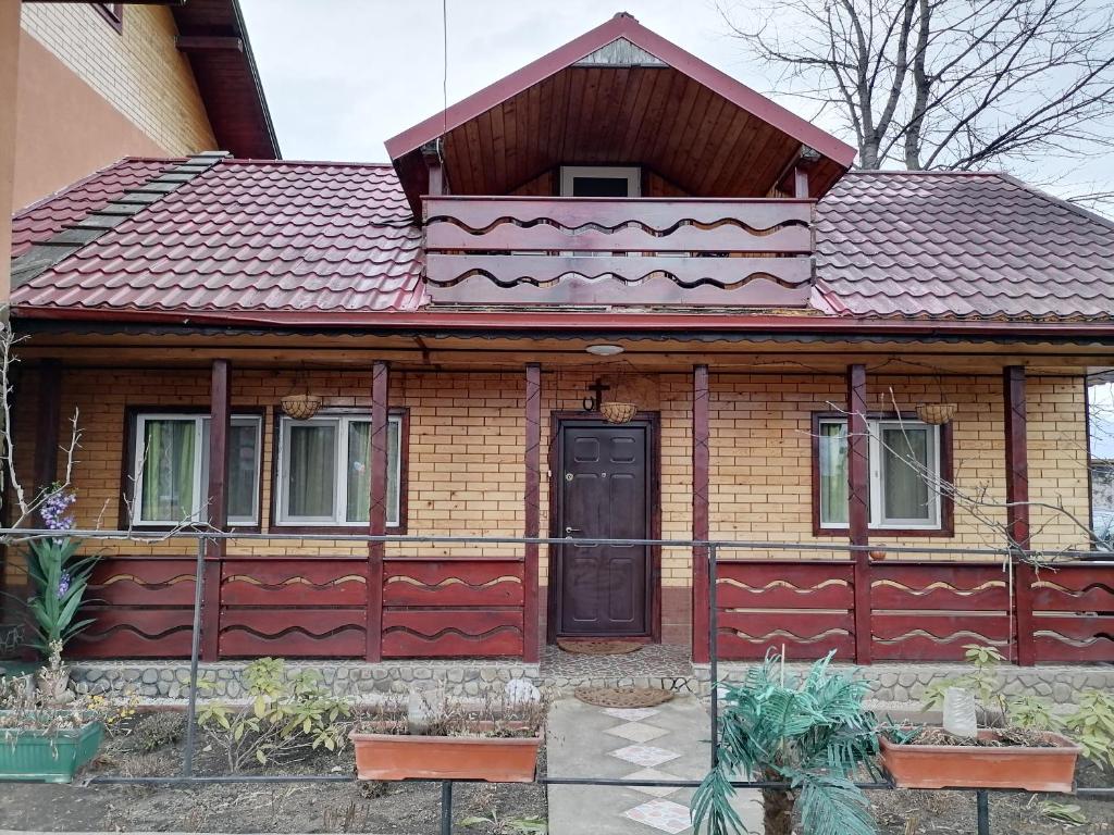 una casa con techo rojo y puerta negra en Domeniul Teodorescu en Piatra Neamţ
